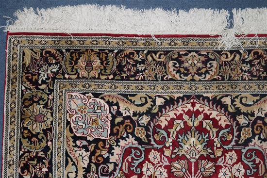 An Indian silk red ground rug